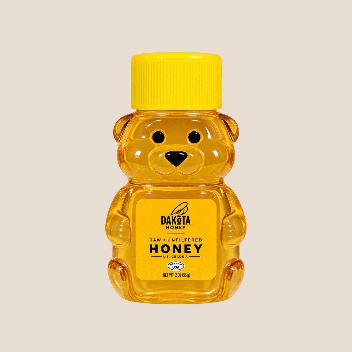 A bear-shaped plastic bottle of Dakota Honey raw, unfiltered honey, centered on a solid light beige background.
