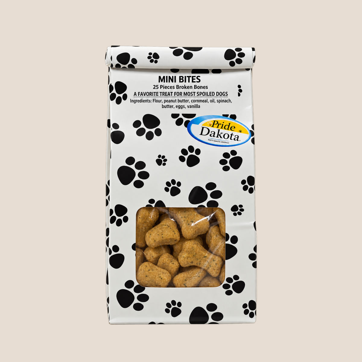A bag of Pride Dakota Mini Bites dog treats, featuring a white bag with black paw print patterns and a clear window showing the golden-brown bone-shaped treats inside.