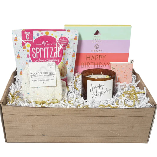 Gift basket with candles, cookies, and greeting cards on a gray background