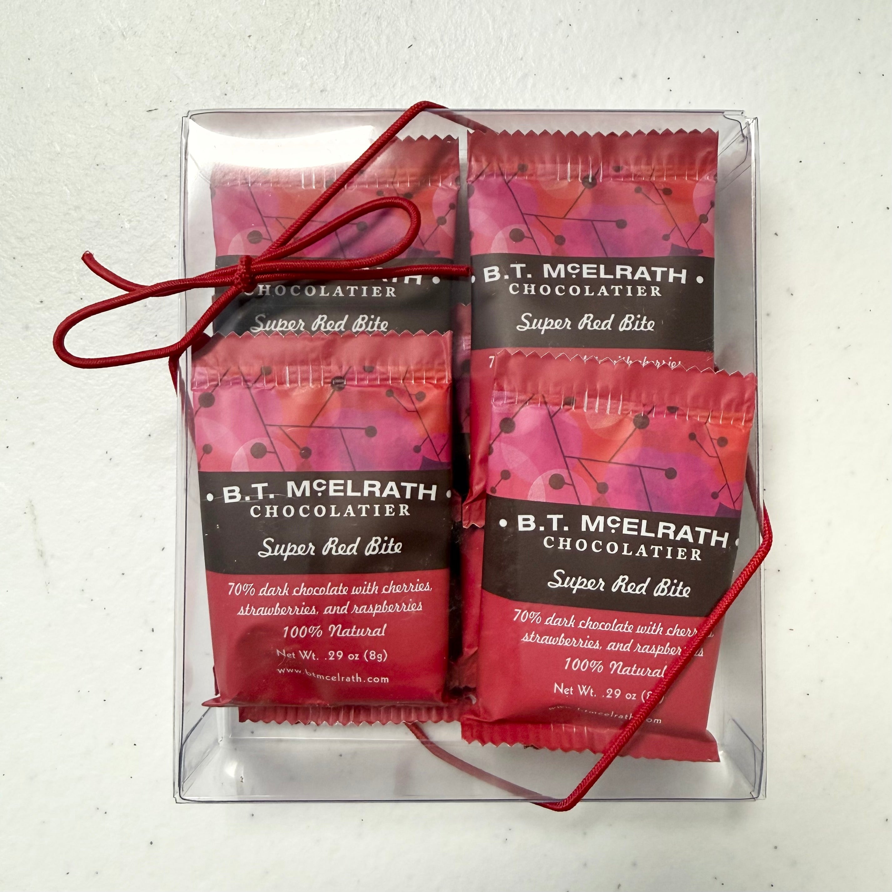 B.T. McElrath Chocolatier Super Red Bite chocolate packages in a clear box on a light gray background