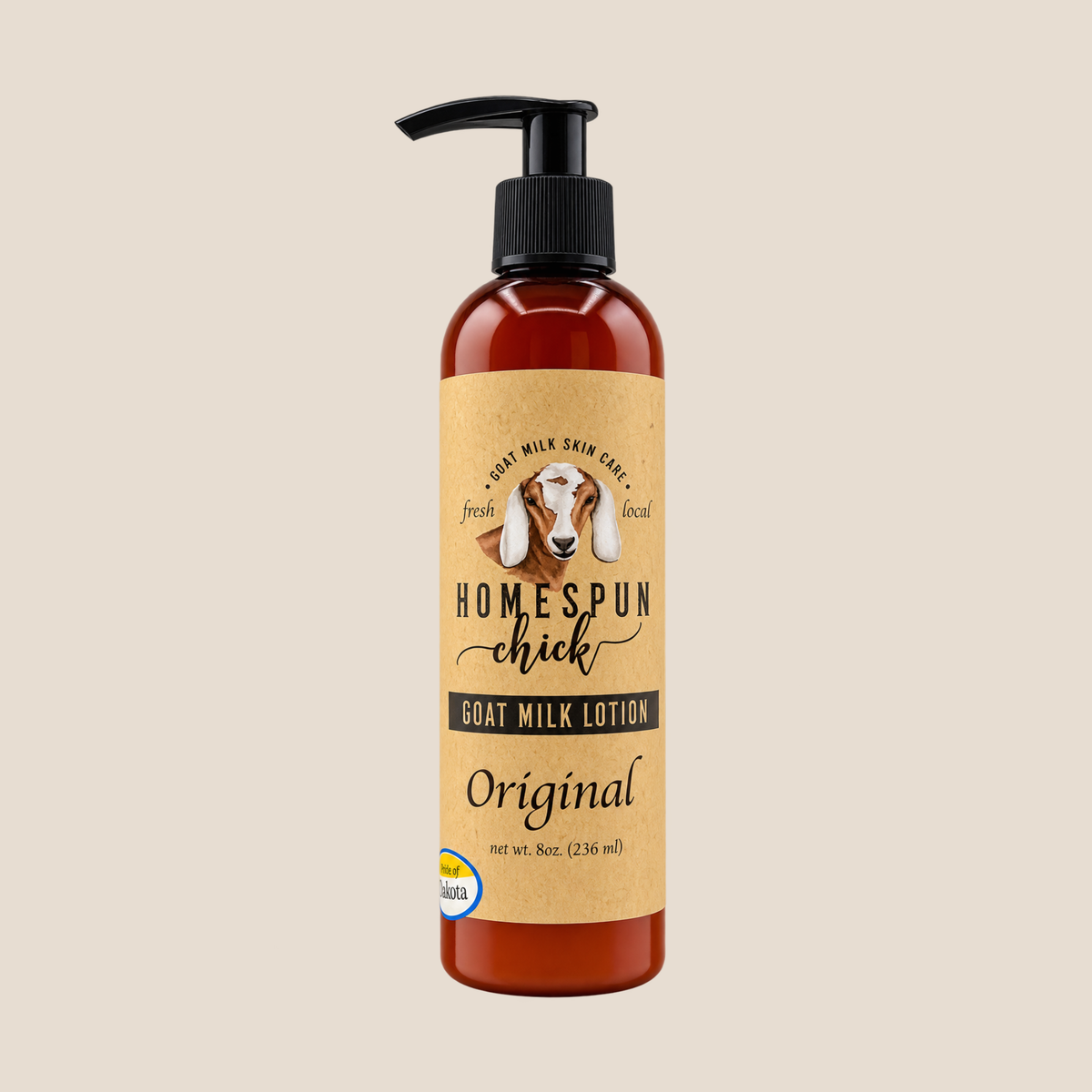 A bottle of Homespun Chick Goat Milk Lotion with a black pump and a tan label featuring a goat illustration, set against a solid beige background.