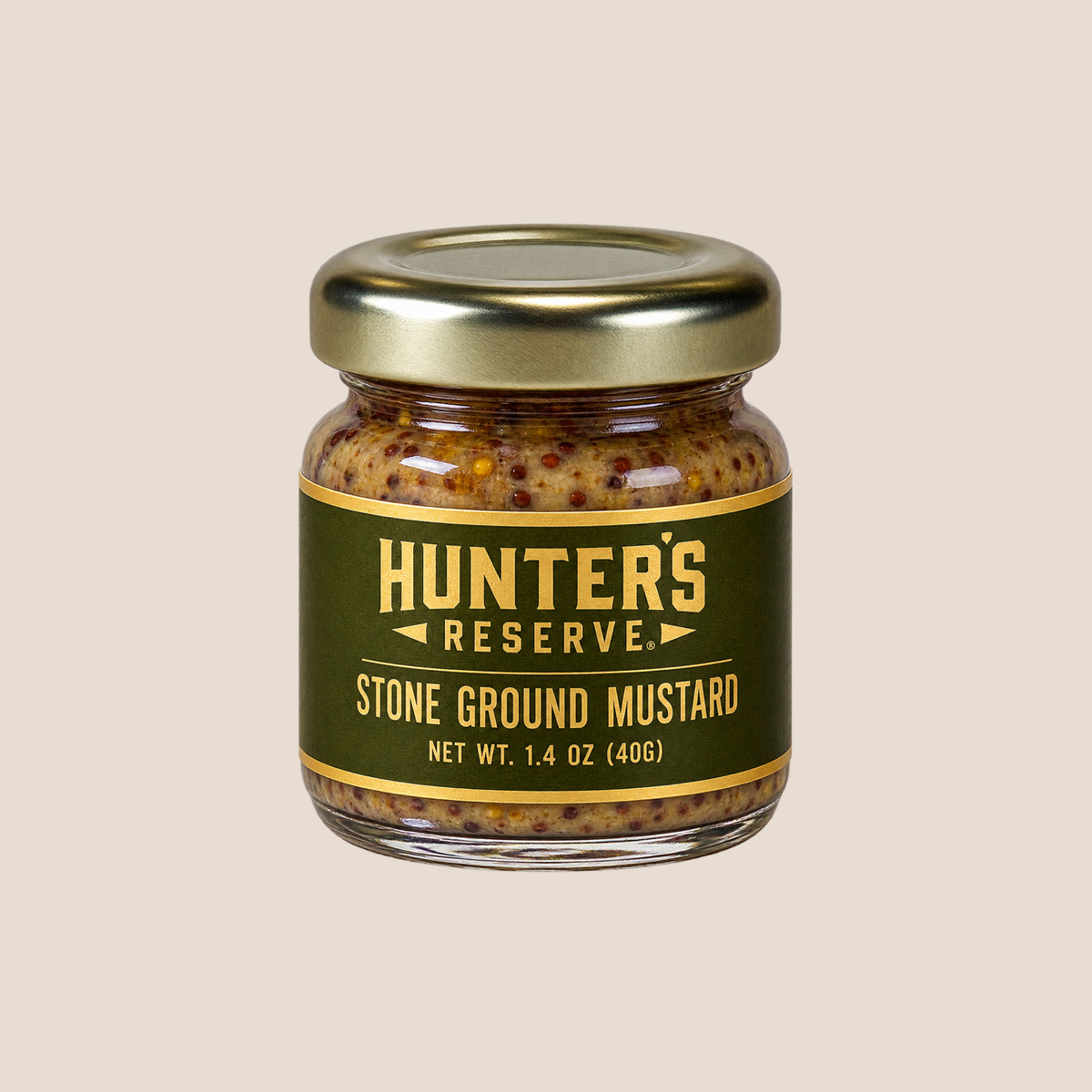 A glass jar of Hunter's Reserve Stone Ground Mustard with a gold metal lid and a dark olive green label, set against a solid light beige background.