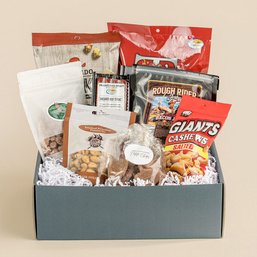 Gift box filled with various snack bags on a beige background