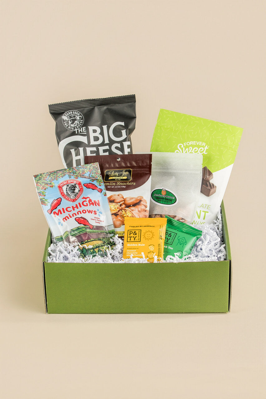 Assorted snacks in a green box on a beige background