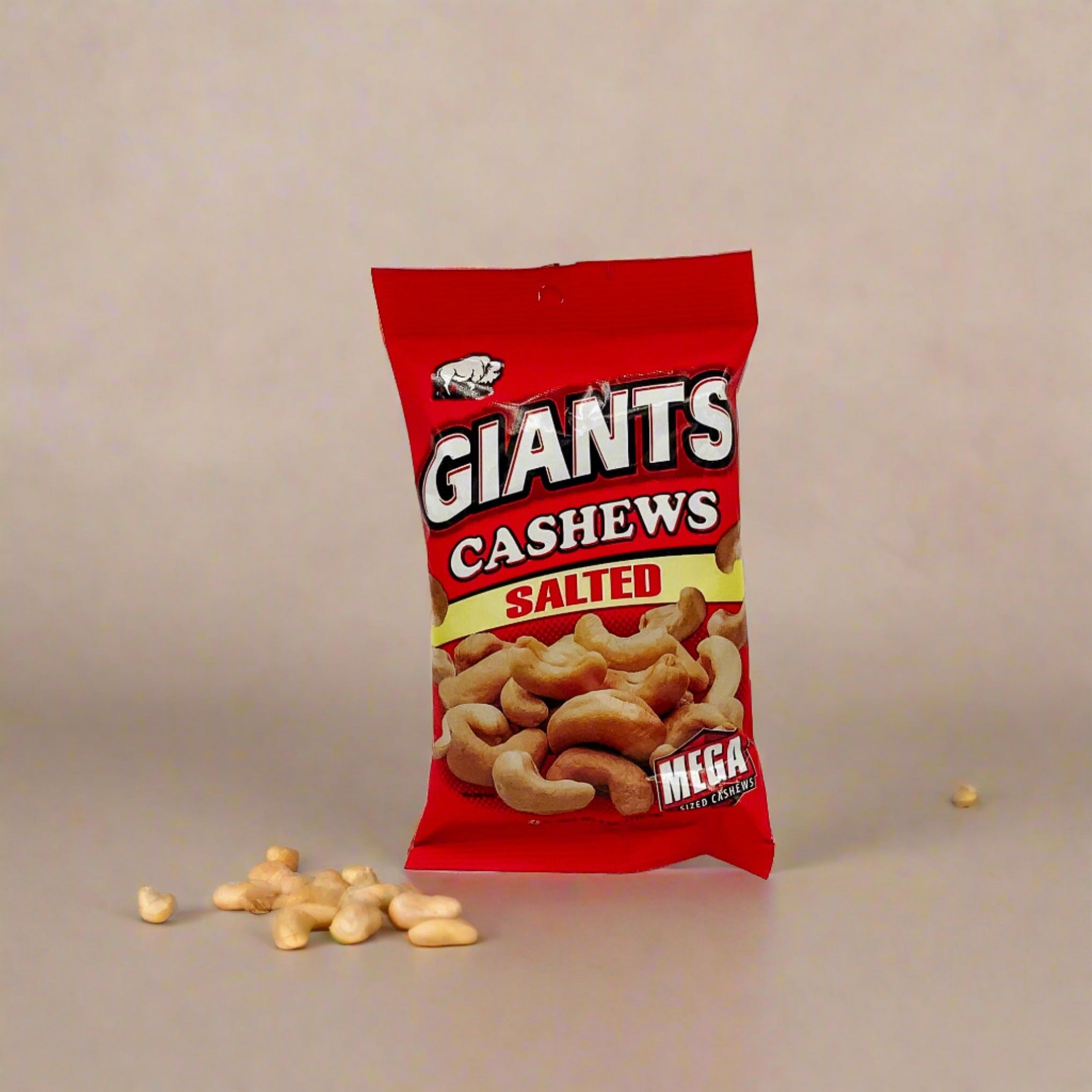A package of Giants Cashews Mega size with a few cashew nuts displayed in front of the packaging.