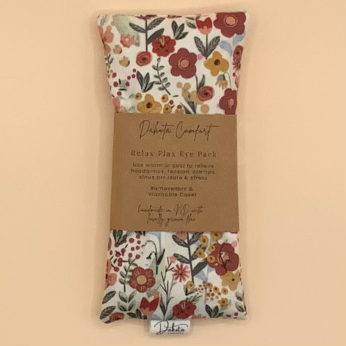 A floral Relax Flax Eye Pack by Delicate Comfort, wrapped in a brown paper band and displayed against a solid beige background.